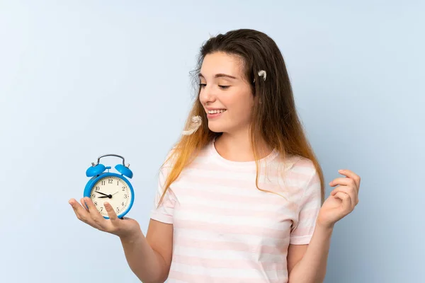 Молодая брюнетка держит винтажные часы на изолированном фоне — стоковое фото