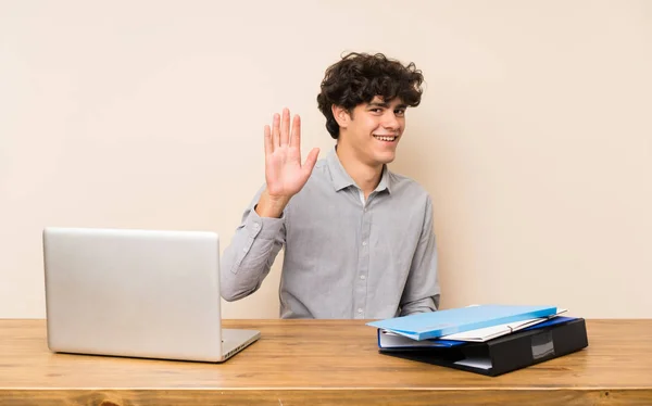 Jovem Estudante Com Laptop Saudando Com Mão Com Expressão Feliz — Fotografia de Stock