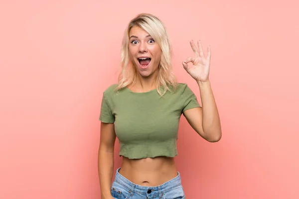 Jonge Blonde Vrouw Geïsoleerde Roze Achtergrond Verrast Tonen Teken — Stockfoto