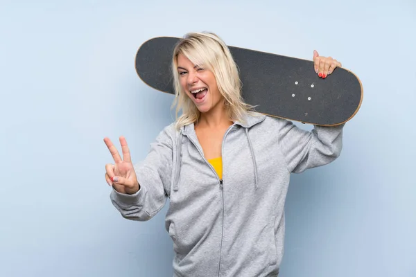Jeune Femme Blonde Sur Fond Isolé Avec Skate Geste Victoire — Photo