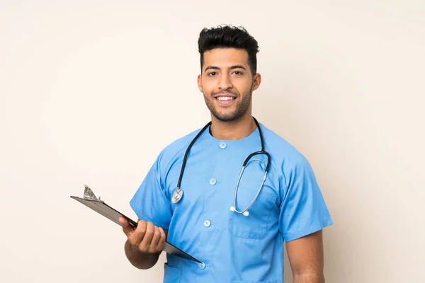 Jovem Homem Bonito Sobre Fundo Isolado Com Vestido Médico Segurando — Fotografia de Stock