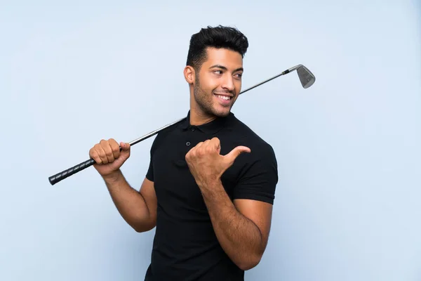 Joven Guapo Jugando Golf Sobre Fondo Azul Aislado Apuntando Hacia —  Fotos de Stock