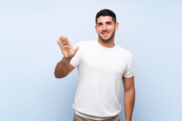 Kaukasische Knappe Man Geïsoleerde Blauwe Achtergrond Salueren Met Hand Met — Stockfoto