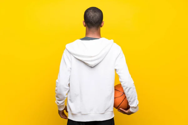 Afro amerikansk basketballspiller over isolert gul rygg – stockfoto