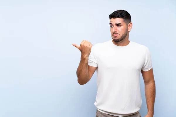 Caucásico Guapo Hombre Sobre Aislado Azul Fondo Infeliz Señalando Lado — Foto de Stock