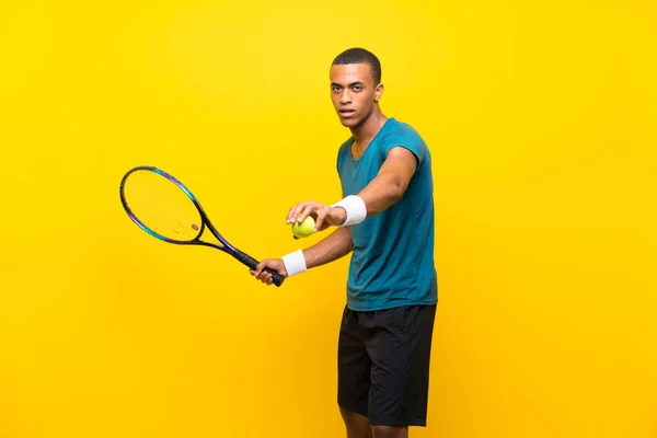 Afro-americano tenista homem sobre fundo amarelo isolado — Fotografia de Stock