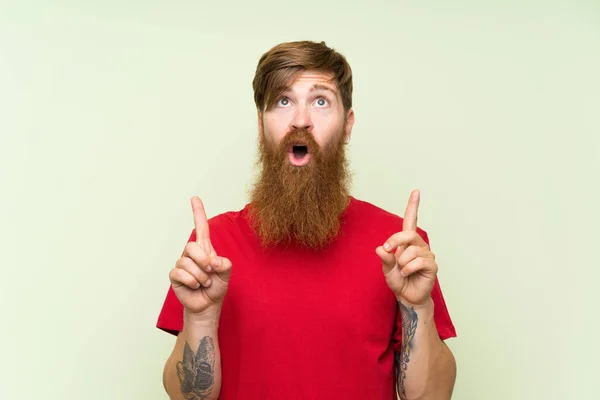 Hombre Pelirrojo Con Barba Larga Sobre Fondo Verde Aislado Apuntando —  Fotos de Stock