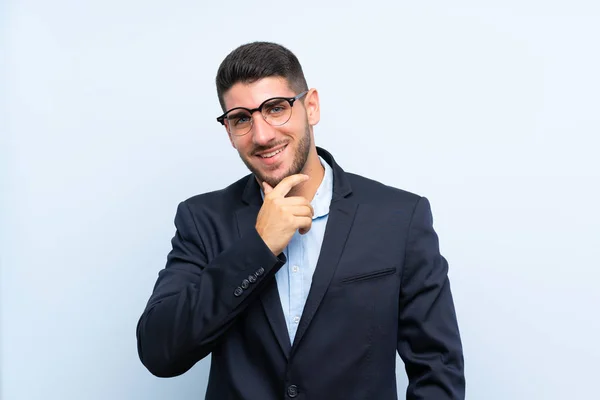 Pohledný Muž Přes Izolované Modré Pozadí Brýlemi Úsměvem — Stock fotografie