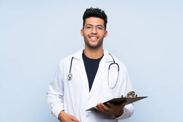 Jovem médico homem sobre isolado parede azul — Fotografia de Stock