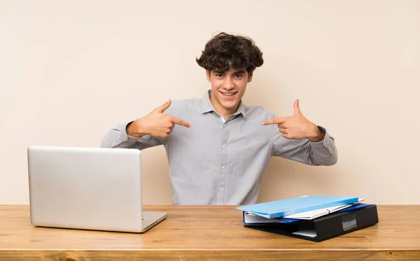Young student man with a laptop proud and self-satisfied