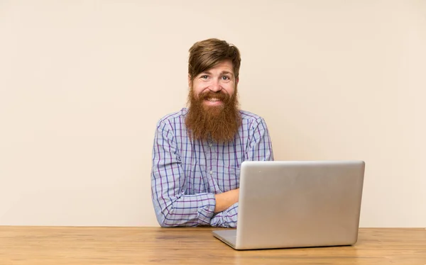 Homem Ruivo Com Barba Comprida Uma Mesa Com Laptop Rindo — Fotografia de Stock