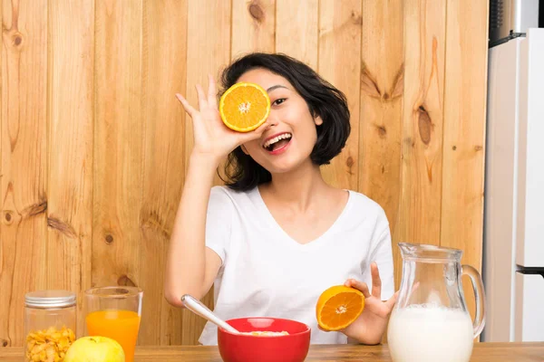 Asyalı Genç kadın kahvaltı tutan bir turuncu — Stok fotoğraf