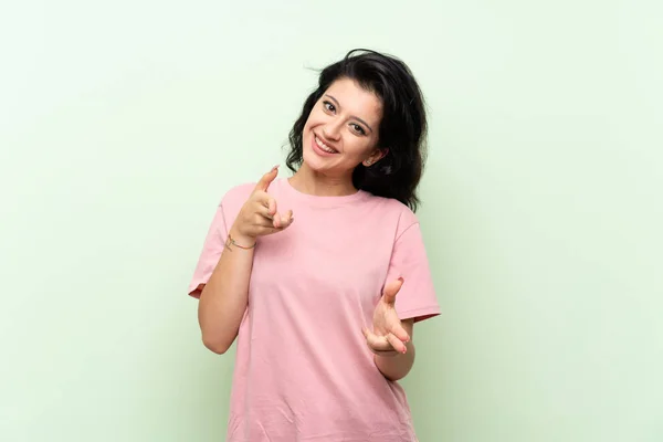 Mujer Joven Sobre Fondo Verde Aislado Apuntando Hacia Frente Sonriendo —  Fotos de Stock