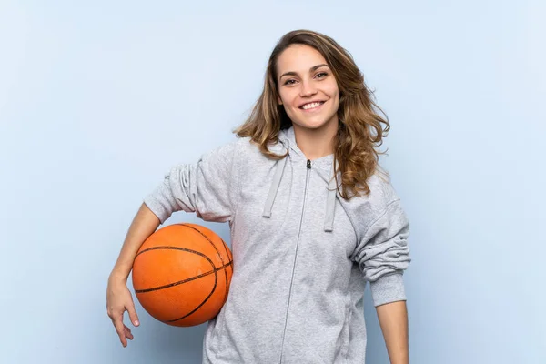 Young blonde woman with ball of basketball