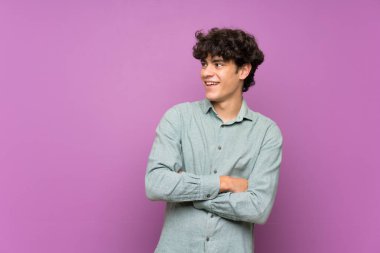 Izole mor duvar üzerinde genç adam mutlu ve gülümseyen