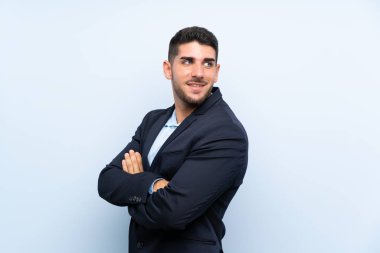 Kolları çapraz ve mutlu izole mavi arka plan üzerinde Yakışıklı adam