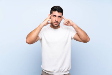 Izole mavi arka plan üzerinde şüpheleri ve düşünme beyaz yakışıklı adam