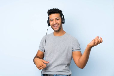 Kulaklık ve dans ile cep telefonu kullanarak izole arka plan üzerinde Genç yakışıklı adam