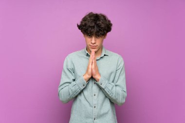 Izole mor duvar üzerinde genç adam birlikte palmiye tutar. Kişi bir şey ister