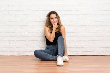 Genç sarışın kadın bir fikir düşünerek katta oturan