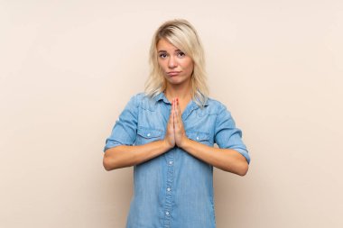 Izole arka plan yalvaran üzerinde genç sarışın kadın