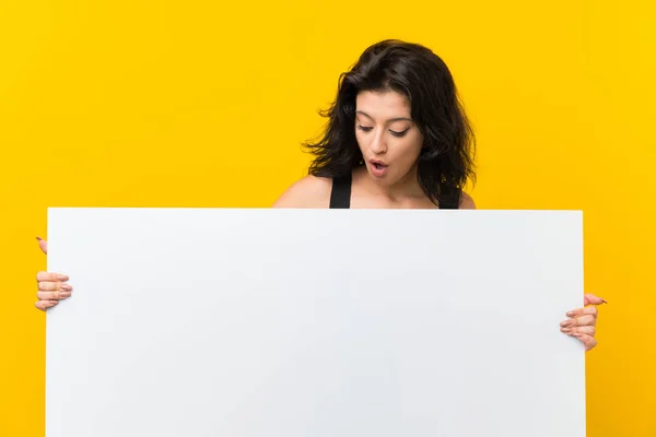 年轻女子在孤立的黄色背景拿着一个空的白色标语牌插入一个概念 — 图库照片