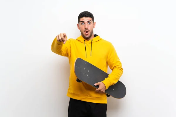 Guapo Joven Patinador Hombre Sobre Aislado Blanco Pared Sorprendida Apuntando —  Fotos de Stock