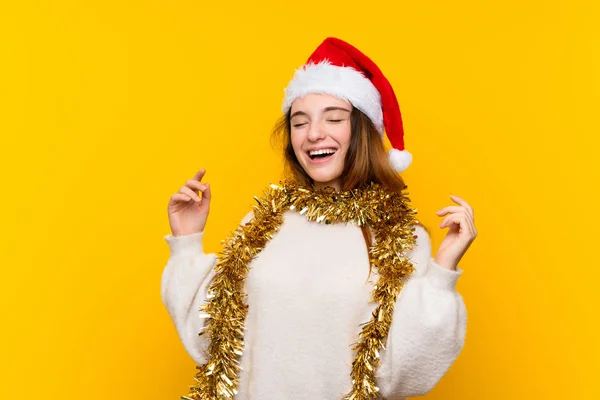 女の子とともにクリスマス帽子上の隔離された黄色の背景笑い — ストック写真