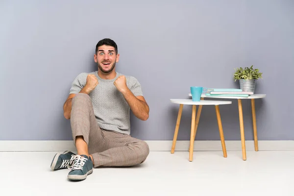 Joven Hombre Guapo Sentado Suelo Celebrando Una Victoria — Foto de Stock