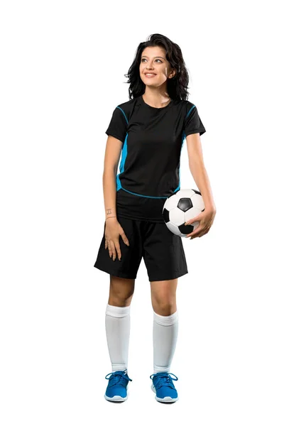 一个年轻的足球女运动员面带微笑地抬起头看着自己孤立的白色背景的全长镜头 — 图库照片