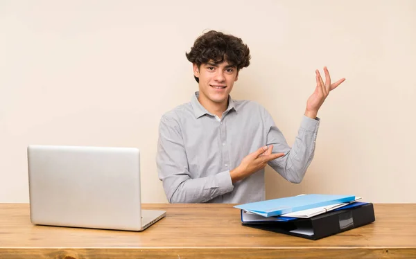 Jovem Estudante Com Laptop Estendendo Mãos Para Lado Para Convidar — Fotografia de Stock