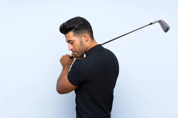 Guapo joven jugando al golf sobre fondo azul aislado —  Fotos de Stock