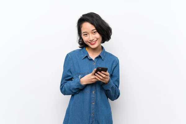 亚洲年轻女子在孤立的白色背景发送信息与手机 — 图库照片