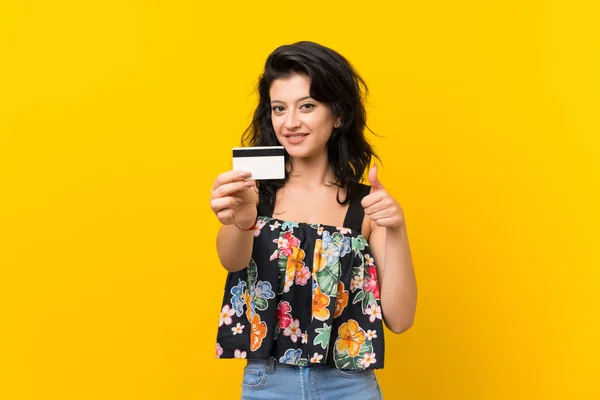 Jonge Vrouw Geïsoleerde Gele Achtergrond Het Houden Van Een Creditcard — Stockfoto