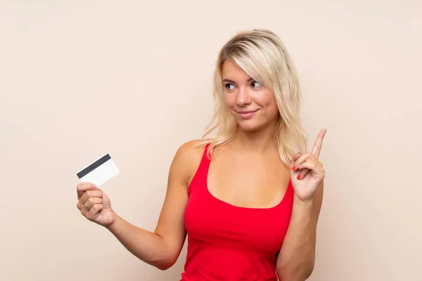 Молода Блондинка Над Ізольованим Тлом Тримає Кредитну Картку — стокове фото