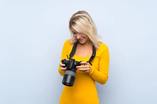 Mujer Rubia Joven Sobre Fondo Aislado Con Una Cámara Profesional — Foto de Stock