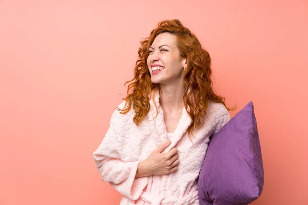 Redhead woman in dressing gown laughing