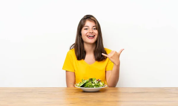 有沙拉的白人女孩在电话里打手势 — 图库照片