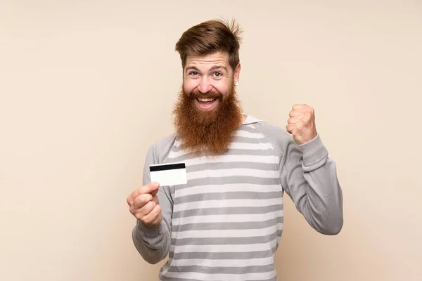 Zrzavý Muž Dlouhými Vousy Nad Izolovaným Pozadím Držící Kreditní Kartu — Stock fotografie