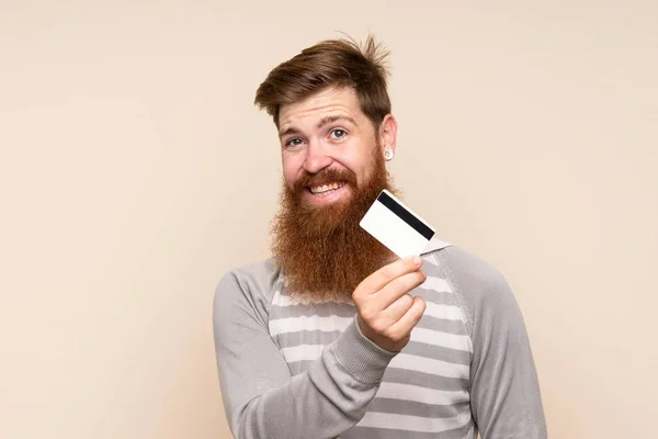 Zrzavý Muž Dlouhými Vousy Nad Izolovaným Pozadím Držící Kreditní Kartu — Stock fotografie