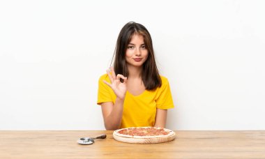 Parmakları ile ok işareti gösteren bir pizza ile Kafkas kız