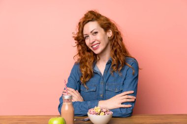 Redhead kadın kahvaltı gevreği ve meyve gülerek sahip