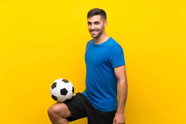 Joven jugador de fútbol guapo hombre sobre aislado pared amarilla —  Fotos de Stock