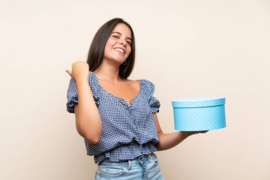 Izole arka plan üzerinde hediye kutusu tutan genç kız