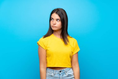 Soyutlanmış mavi arka planda genç bir kız şüpheli hareketler yapıyor.