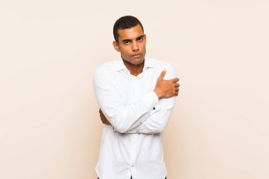 Genç yakışıklı esmer adam izole edilmiş arka planda donuyor.