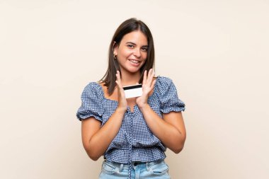 Bir kredi kartı tutan izole arka plan üzerinde genç kız