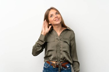 Litvanyalı sarışın kız, izole edilmiş beyaz arka planda elini kulağına koyarak bir şeyler dinliyor.