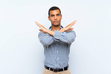 Genç, yakışıklı, esmer, soyutlanmış, mavi arka planda bir adam.