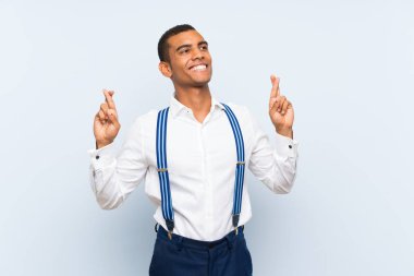 İzole edilmiş arka planda pantolon askısı olan yakışıklı esmer bir adam.